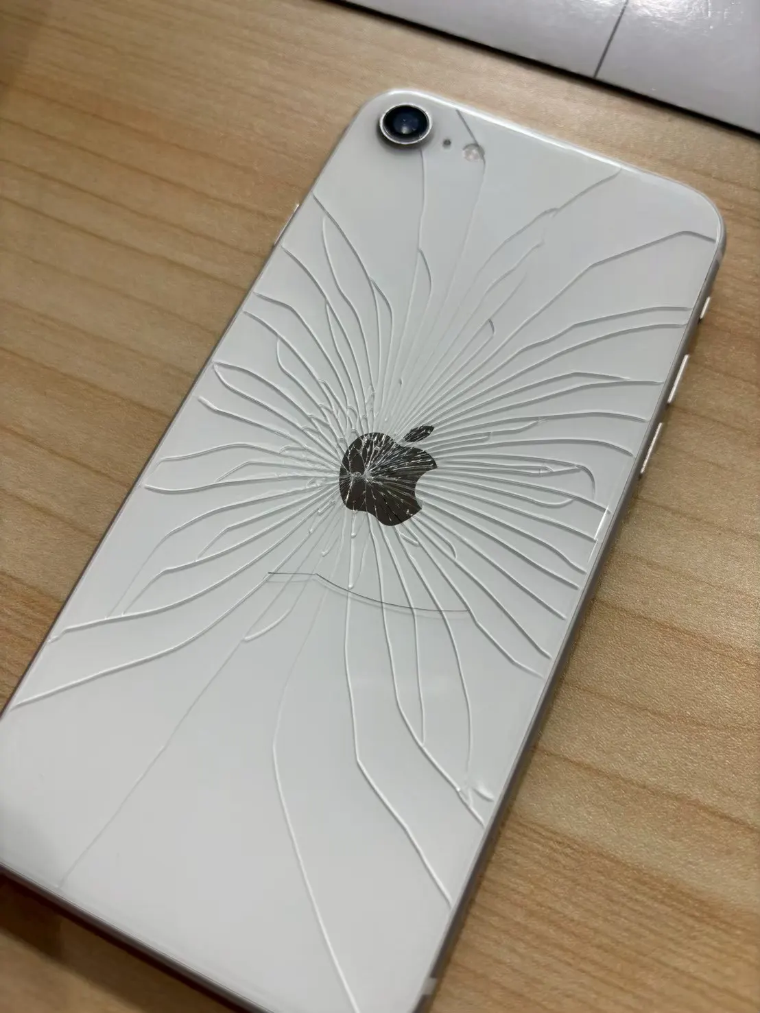 背面ガラスにひび割れが広がったiPhone